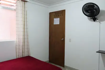 a room with a door and a fan on the wall at Living Poblado Manila 3027 Habitación Individual in Medellín
