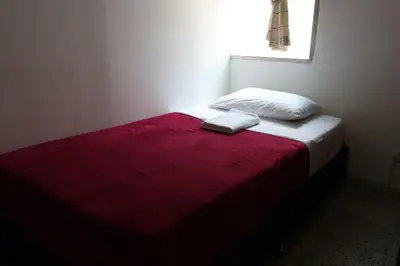 a bed with a red and white blanket and a window at Living Poblado Manila 301 E Habitación Doble in Medellín