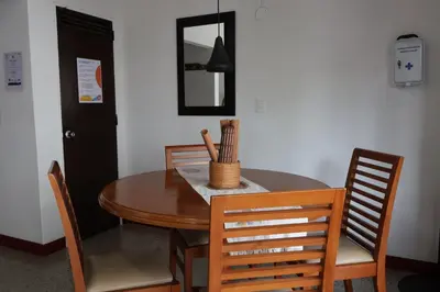 a dining room table with chairs and a mirror at Living Poblado Manila 301 E Habitación Doble in Medellín