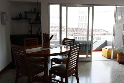 a wooden table and chairs in a room with a window at Living Poblado Manila 301 G Hab Doble con Baño in Medellín