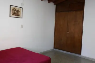 a bedroom with a bed and a wooden cabinet at Living Poblado Manila 301 B Habitación Individual in Medellín