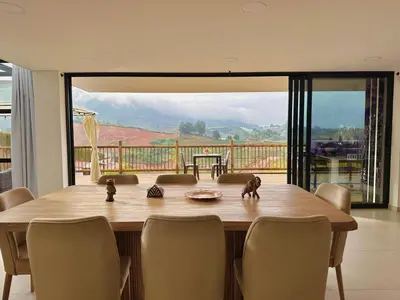 a dining room table with chairs and a large window at Fénix in Marinilla