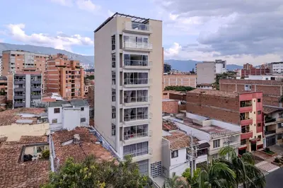 a tall white building in a city with buildings at Apartamento en Laureles, con piscina y parquedero 401 in Medellín