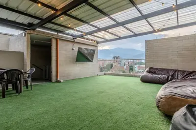 a large room with a green carpeted floor and a patio at Apartamento 2BR Parqueadero y Piscina 502 in Medellín