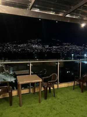 a table and chairs on a balcony with a view of a city at Apartamento 2BR Parqueadero y Piscina 502 in Medellín