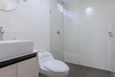 a white bathroom with a toilet and a shower at Apartamento 2BR Parqueadero y Piscina 502 in Medellín