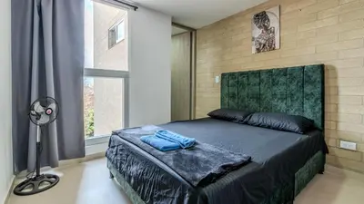 a bedroom with a bed and a lamp and a window at Apartamento en laureles con piscina y parqueadero 402 in Medellín