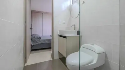 a small bathroom with a toilet and a sink at Apartamento en laureles con piscina, parqueadero 302 in Medellín