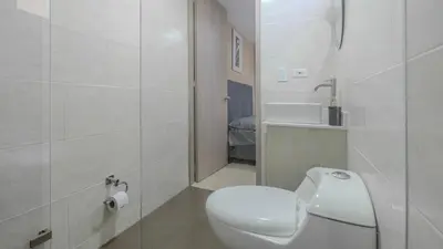 a white bathroom with a toilet and a sink at Apartamento en laureles con piscina, parqueadero 302 in Medellín