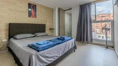 a bedroom with a bed with blue towels on it at Apartamento 2BR Parqueadero y Piscina 202 in Medellín