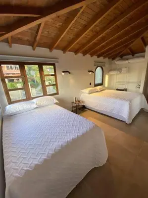two white beds in a room with windows at Casa de Campo completa ubicada en Santa Elena in Santa Elena