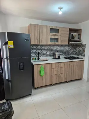 a kitchen with a black refrigerator and wooden cabinets at Apartamento Super Exclusivo in Medellín