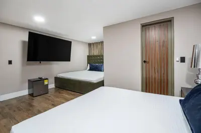 a hotel room with a bed and a flat screen tv at white house poblado in El Poblado