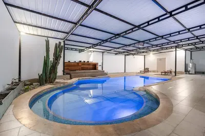 a large swimming pool with blue water in a building at white house poblado in El Poblado