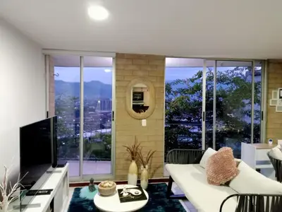 a living room with a white couch and a large window at Apartment in Palmas - Poblado in Medellín