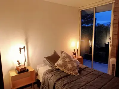 a bedroom with a bed and a large window at Apartment in Palmas - Poblado in Medellín
