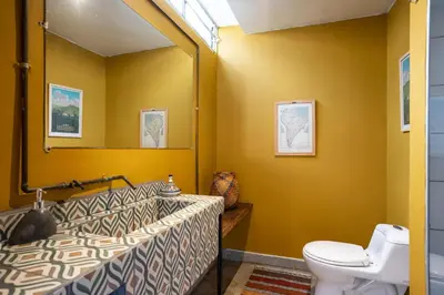 a bathroom with a toilet and a mirror at Colonial Villa in Laureles, Unique&Special House in Medellín