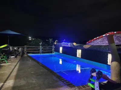 a swimming pool at night with blue lighting at Parcela - Casa del árbol in Doradal