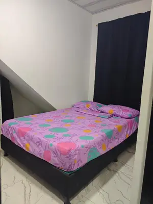 a small bed in a bedroom with a purple comforter at Parcela - Casa del árbol in Doradal