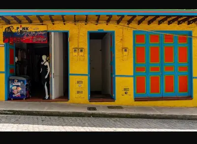 a building with colorful doors and a man standing in the doorway at Suite Encanto in Jericó