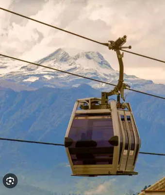 a ski lift with a snow covered mountain in the background at Apartamento , frente a la universidad autónoma , edificio urban in Manizales