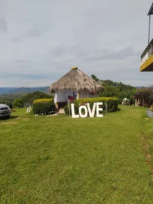 a sign that says love sitting in a grass field at Cabaña Campestre San Gabriel in Angostura