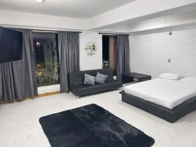 a bedroom with a bed and a couch at Loft en el exclusivo barrio Poblado - Medellín in Medellín