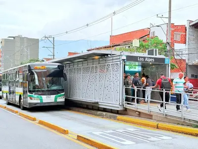 people are getting on a bus at a bus stop at Aparta estudio 205- Casa Bendita in Medellín