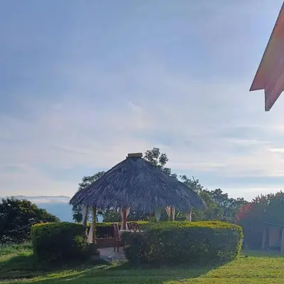 a hut with a table and chairs in the grass at Chalet Campestre San Gabriel in Angostura