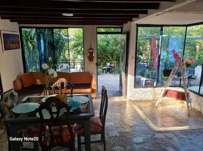 a living room with a table and a couch and windows at Hermoso Duplex campestre in Honda