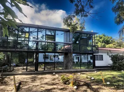 a glass house with a tree in front of it at Hermoso Duplex campestre in Honda