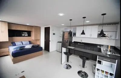 a bedroom with a bed and a kitchen in it at Espacio Ideal para Disfrutar Medellin in Medellín