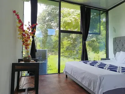 a bedroom with a bed and a large window at Hermoso Duplex campestre in Honda