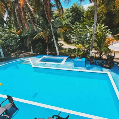 a pool with chairs and palm trees in a resort at Hermoso Duplex campestre in Honda