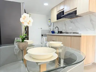 a kitchen with a glass table with bowls on it at Vive Medellin 401 in Medellín