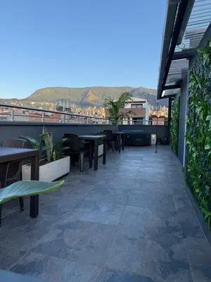 a patio with tables and benches on a building at Vive Medellin 401 in Medellín