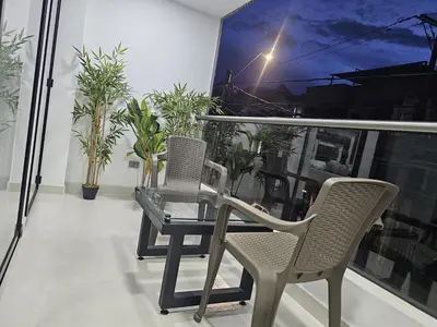 a table and chairs on a balcony with plants at Vive Medellin 302 in Medellín