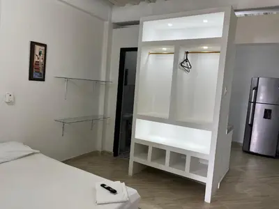 a white room with a bed and a refrigerator at Apartamento Napoles in Doradal