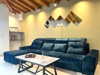 a living room with a blue couch and a table at Casa Dorada - Confort a solo una cuadra del Parque in Carmen de Viboral