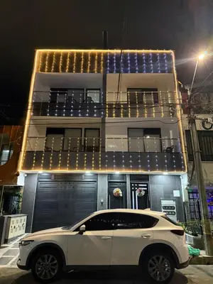 a white car parked in front of a building at night at 201New apartment perfect location Close to poblado in Medellín