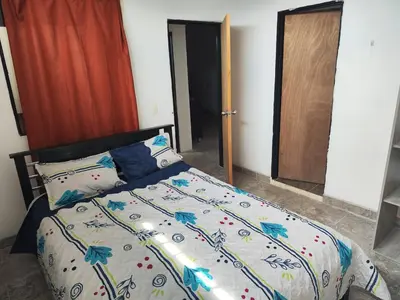 a bedroom with a bed with a colorful comforter at Augusto Hernandez in Santa Fe de Antioquia