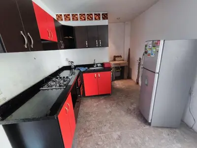 a kitchen with red cabinets and a refrigerator at Spacious and calm place to stay in Santa Fe de Antioquia