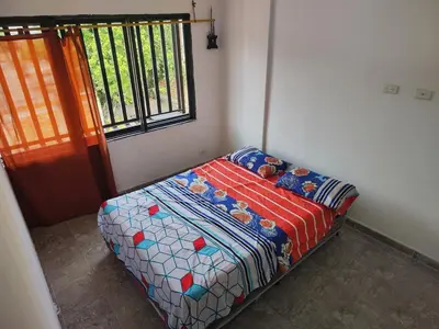 a small bed in a room with a window at Spacious and calm place to stay in Santa Fe de Antioquia
