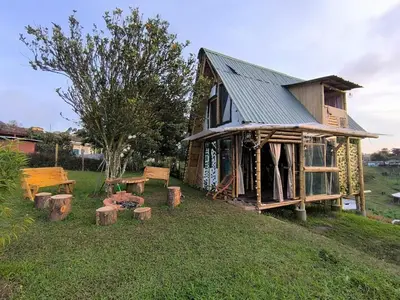 a log cabin with a table and benches in the grass at Marinilla - Cabañas Perlas Black - in Marinilla