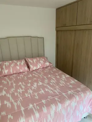 a bedroom with a pink bed and a wooden cabinet at Magnífico apto para disfrutar su estadia in Medellín