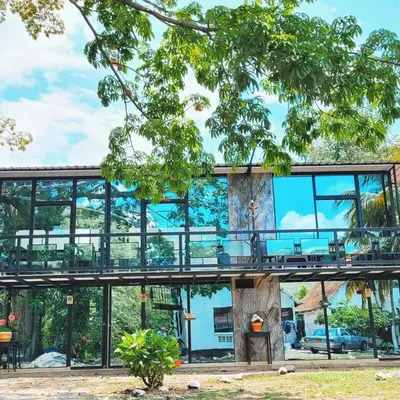 a glass house with a balcony in a park at Beautiful duplex in Honda