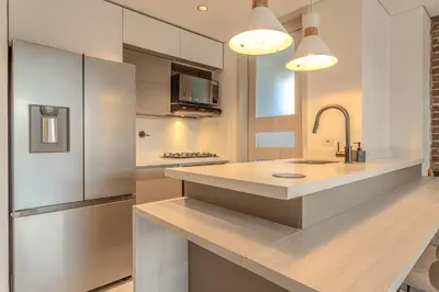 a kitchen with a stainless steel refrigerator and a counter at Villa reservoir view in Guatapé