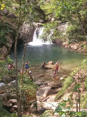 a group of people standing in a river with a waterfall at Cabin with River in San Rafael