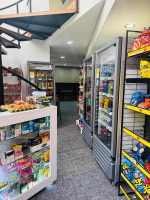 a store with two refrigerators and shelves of goods at Gran loft cerca al tesoro y al lleras 121 in Medellín