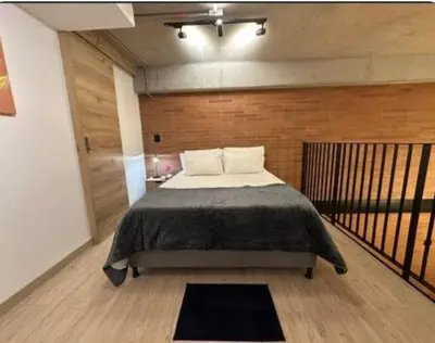 a bedroom with a bed and a wooden wall at Hermoso Loft in Medellín